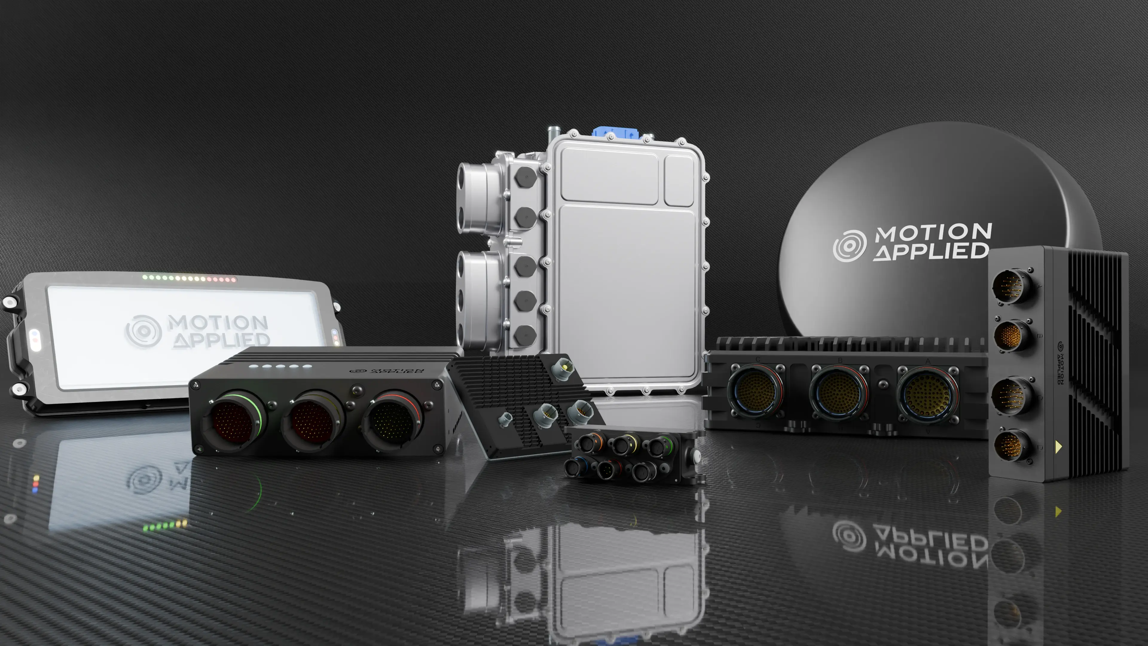 Collection of Motion Applied electronic hardware products displayed on a reflective dark surface, including control units, interface modules, connector hubs, and a branded antenna.